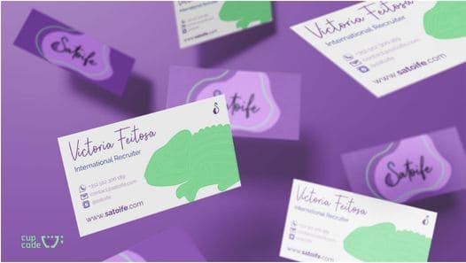 Mockups de cartões de visita da Satoife destacando o nome 'Victoria Feitosa, cargo 'International Recruiter', e informações de contato, integrando elementos gráficos que simbolizam a marca, criados pela Cupcode.

                